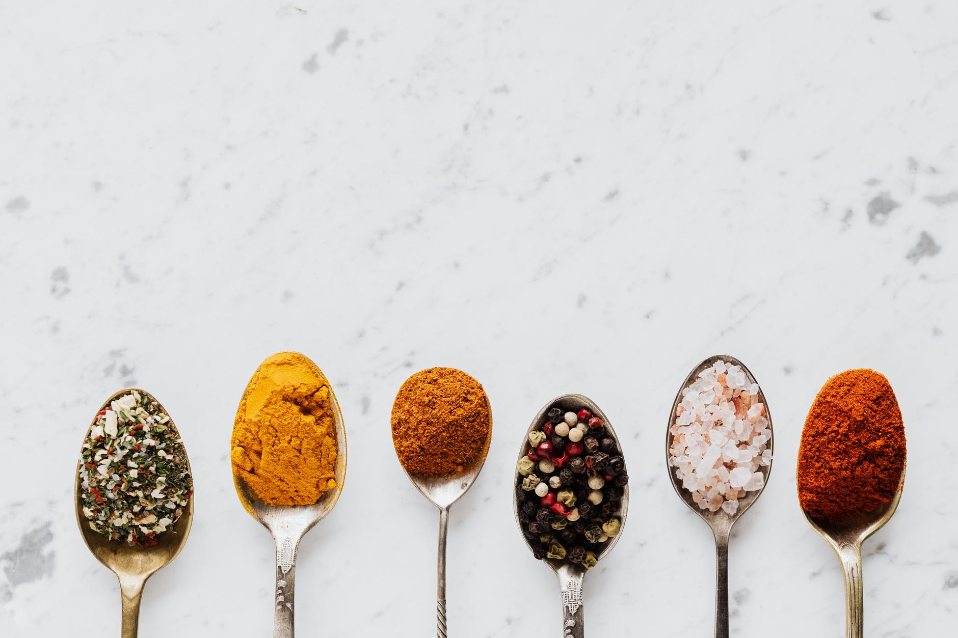 composition of spoonfuls with various spices for healthy food preparing
